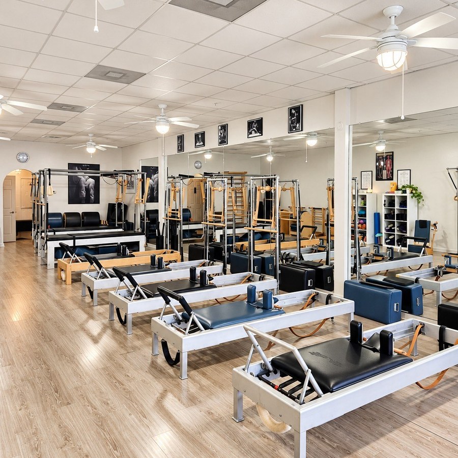 Wide view of reformers and Pilates apparatus inside International Pilates Center