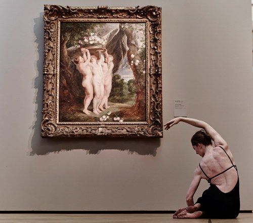 Jamie Trout practicing Pilates beside artwork