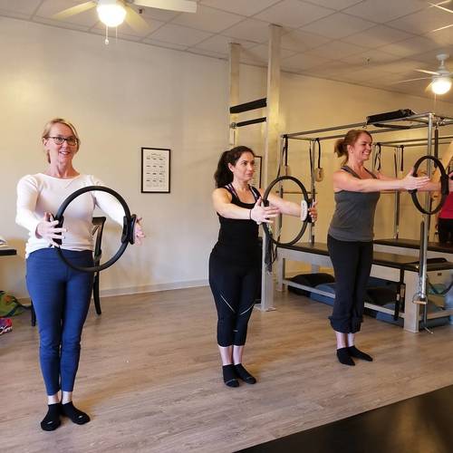 Students practicing Pilates with magic circles